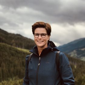 Vrouw poseert voor een bergachtig landschap