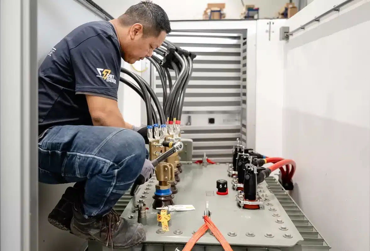 Medewerker van DBT-Energie aan het werk met een transformator in een compactstation